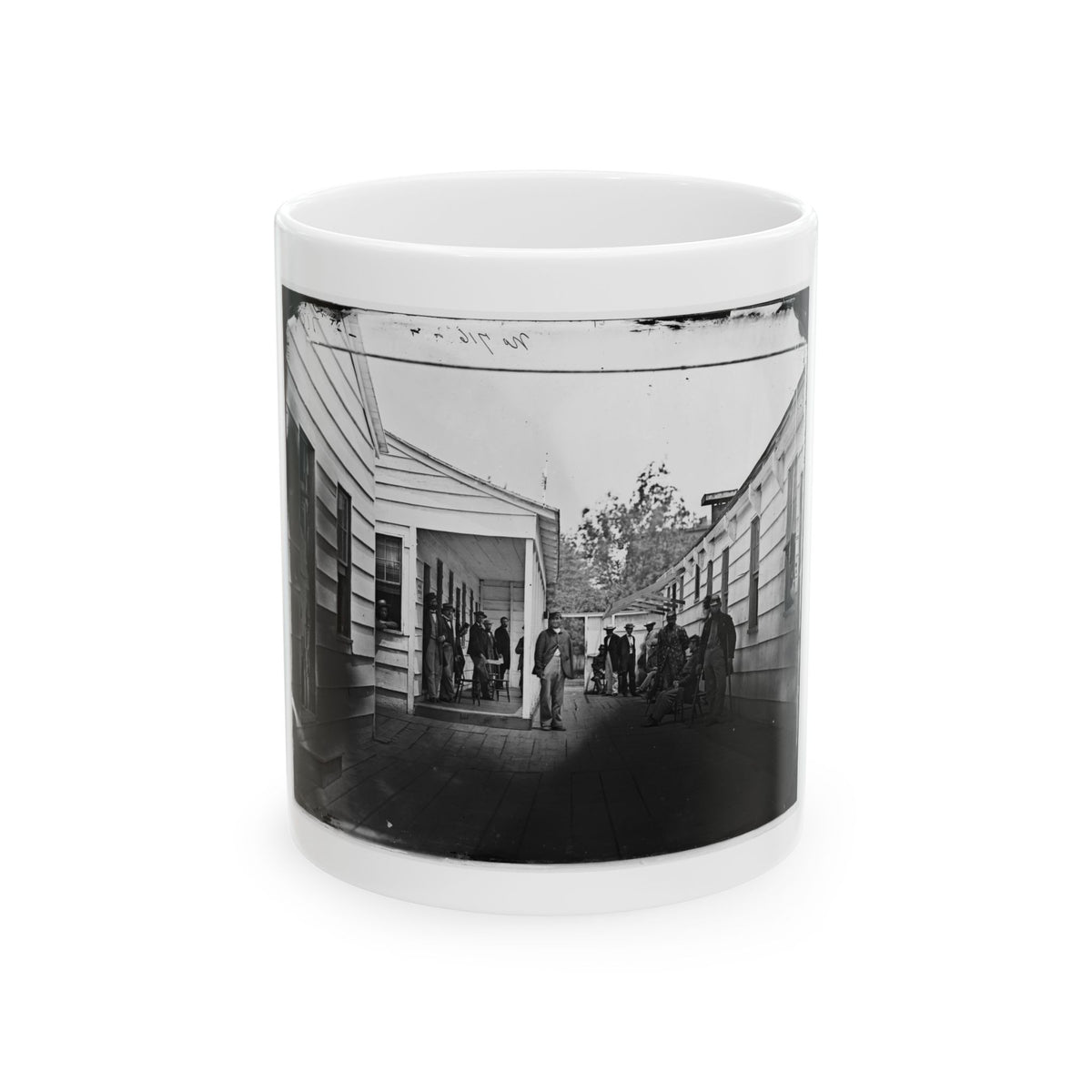 Monochrome 1860s scene of men on a wooden plank walkway between clapboard buildings, one leaning on a crutch.