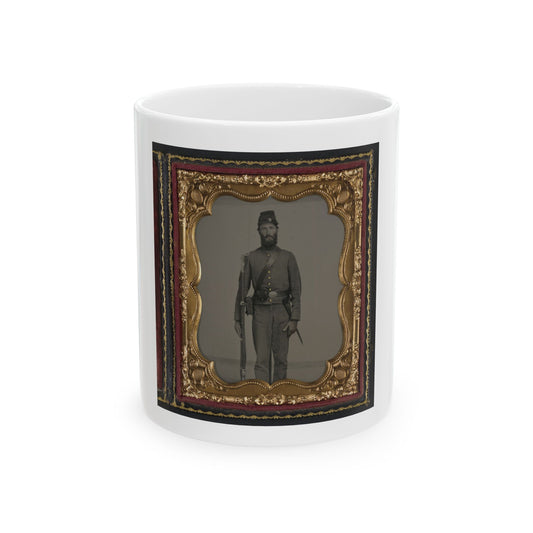 Monochrome tintype of a bearded soldier in a kepi and grey uniform holding a rifle, in a gilt scalloped frame.