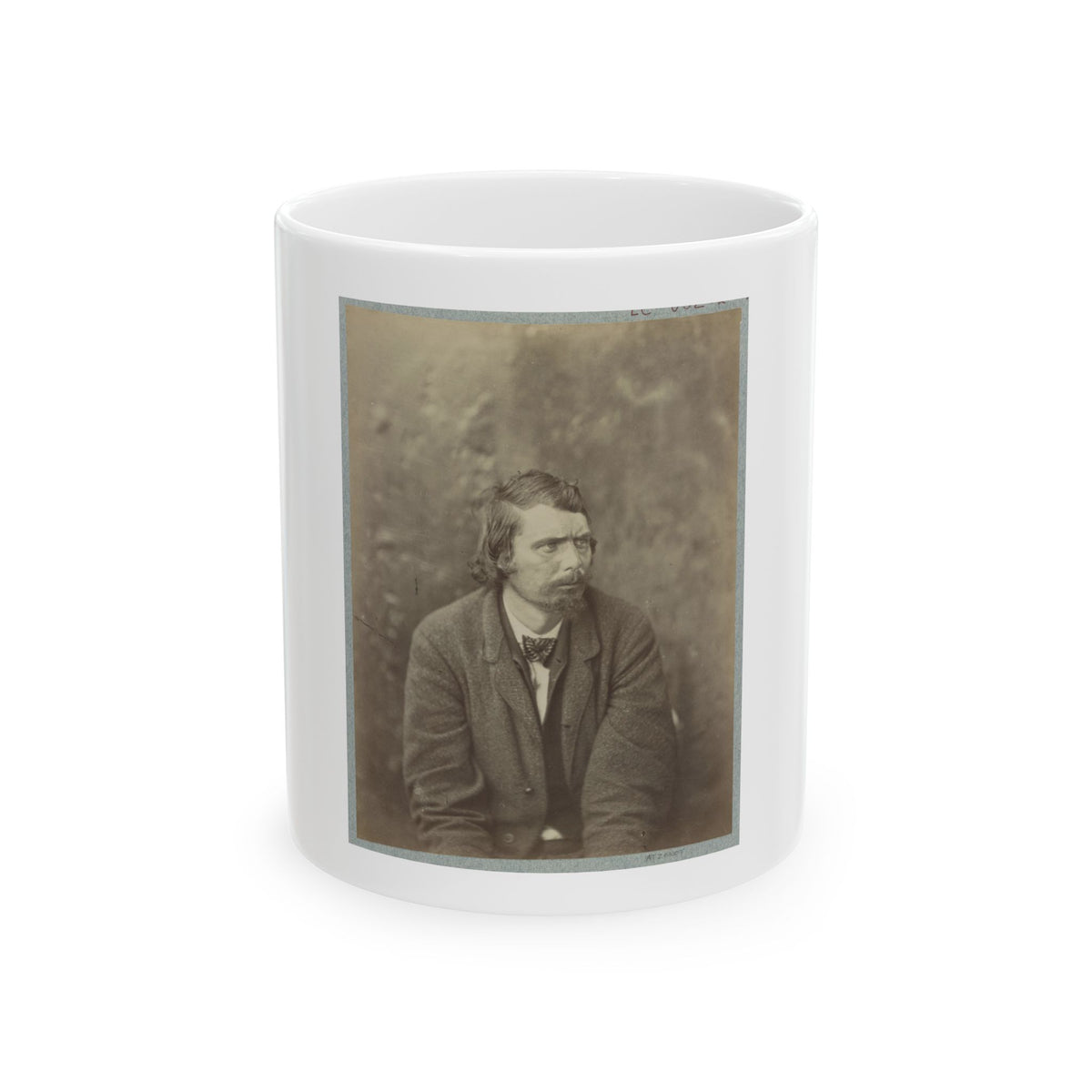 Sepia studio portrait of a bearded man in a tweed jacket and bow tie against a soft mottled backdrop.