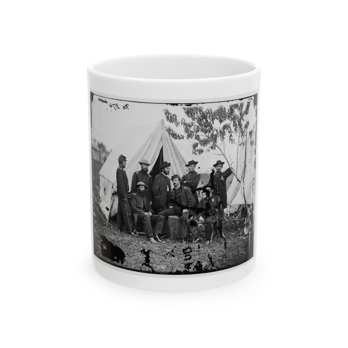 Black and white print of eight Civil War era soldiers posing in front of white canvas tents on grass.