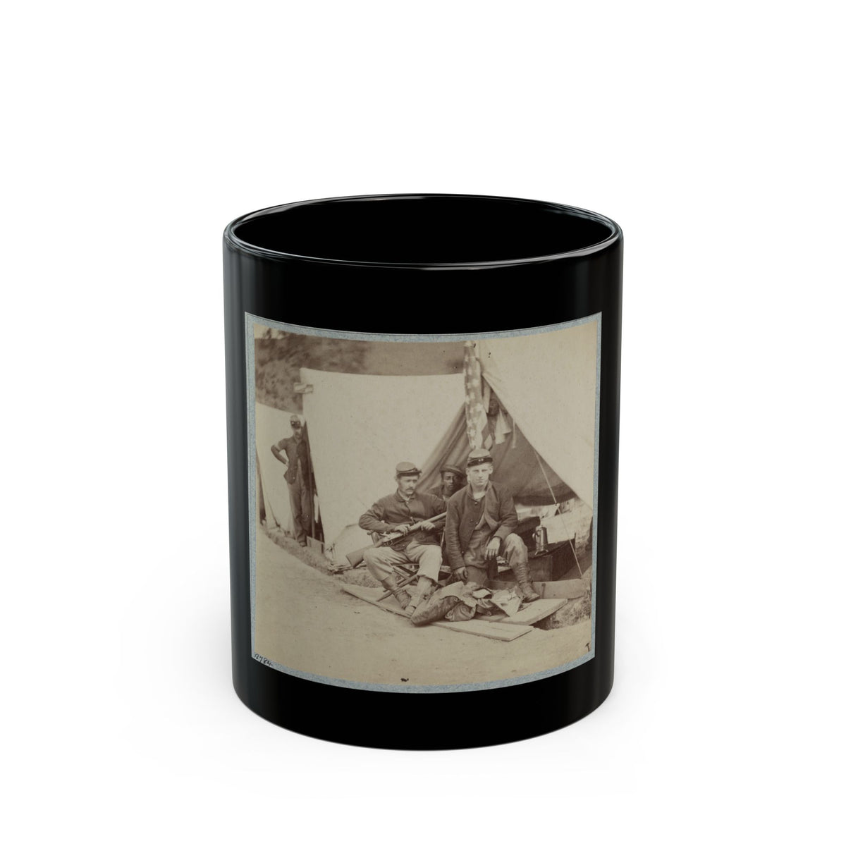 Sepia view of four soldiers in caps resting by a white canvas tent, one holding a rifle in a camp.
