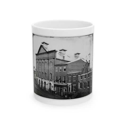 Black and white 1860s view of a brick building with arched openings and bunting swags above a street.