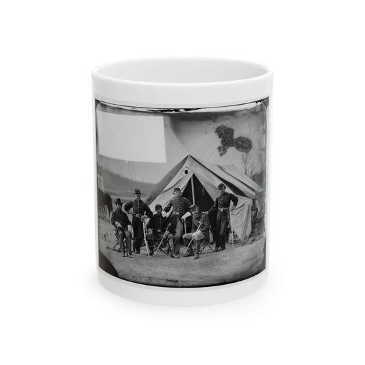 Black and white view of six 1860s officers posed before a canvas tent, some seated on folding chairs.