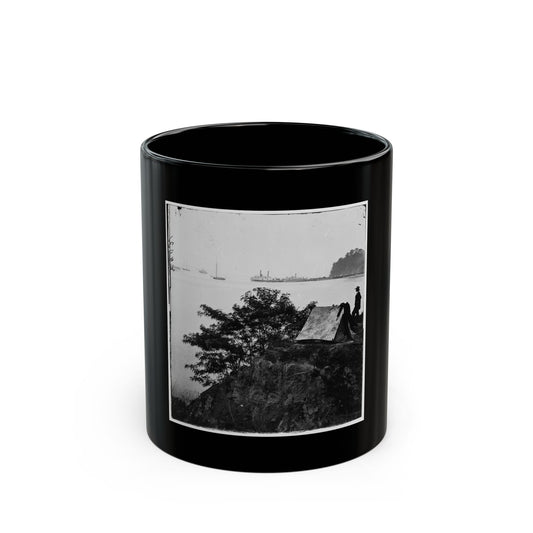 Black and white print of a man in a wide-brimmed hat beside a small tent on a riverbank bluff.