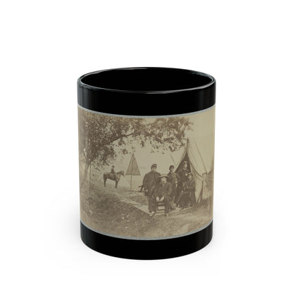 Sepia print of uniformed men posed before a canvas tent in a shaded camp, with a mounted rider nearby.