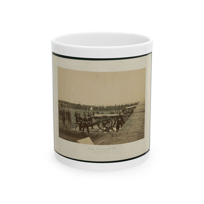 Sepia print of Civil War artillery soldiers posed beside a large field cannon on an earthwork.