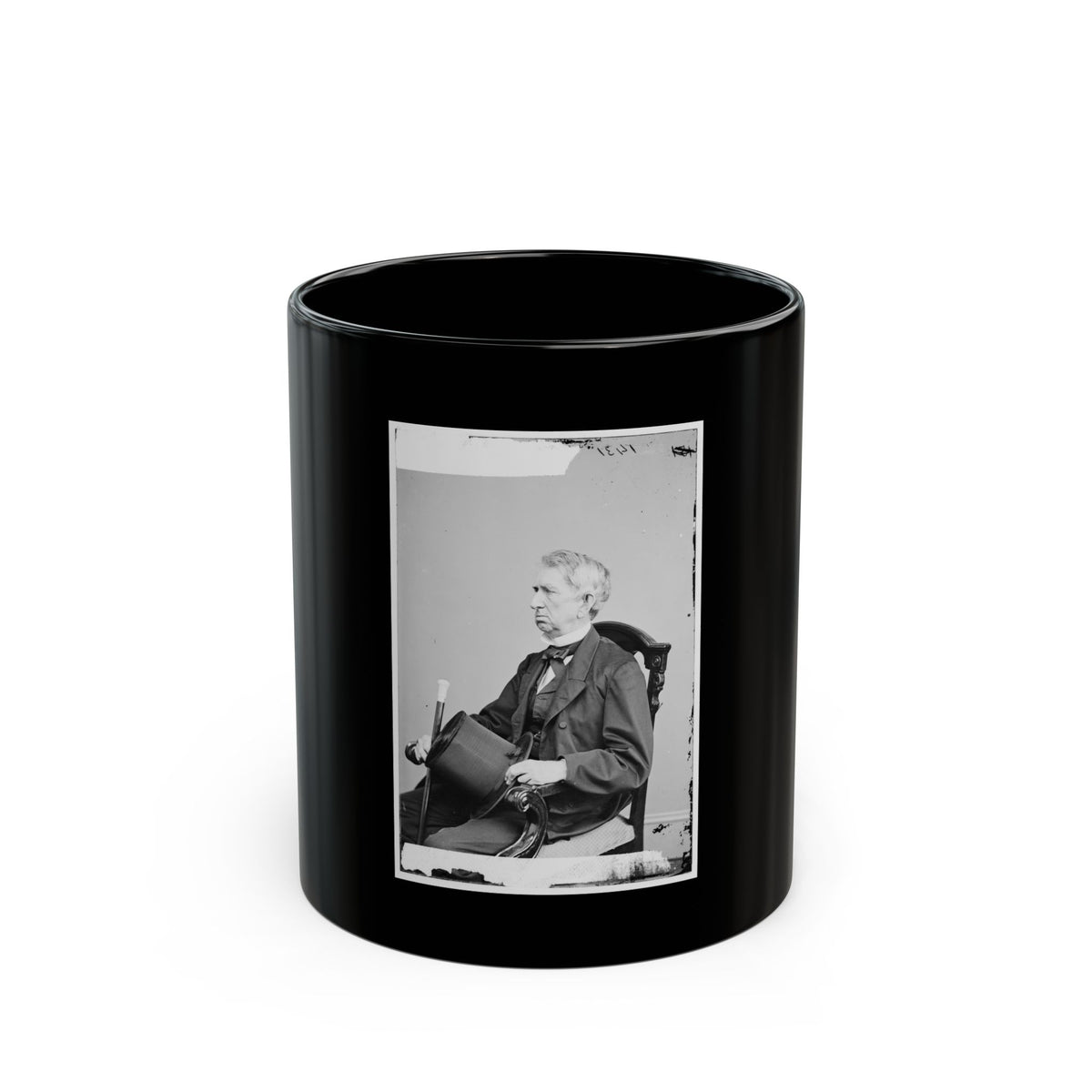 Black and white portrait of an elderly man in a dark suit, seated in a carved chair and holding a top hat.