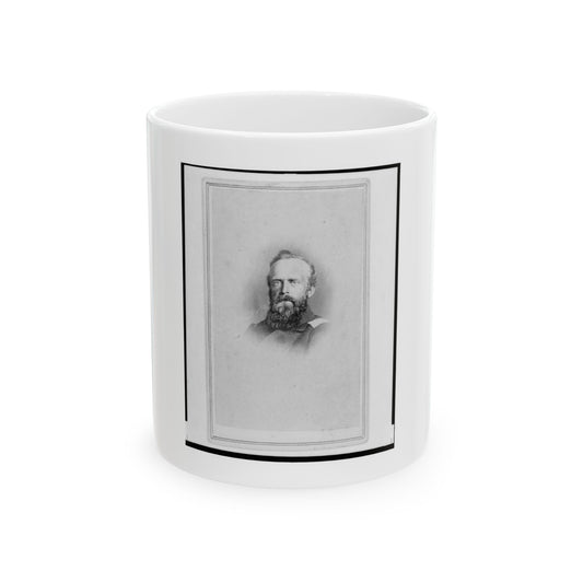 Monochrome studio portrait of a bearded man in a dark military coat, set inside a thin rectangular card border.