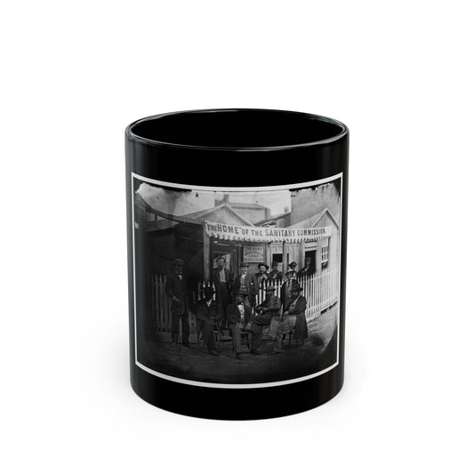 Black and white 19th-century view of men in hats outside a wooden lodge with a Sanitary Commission banner.