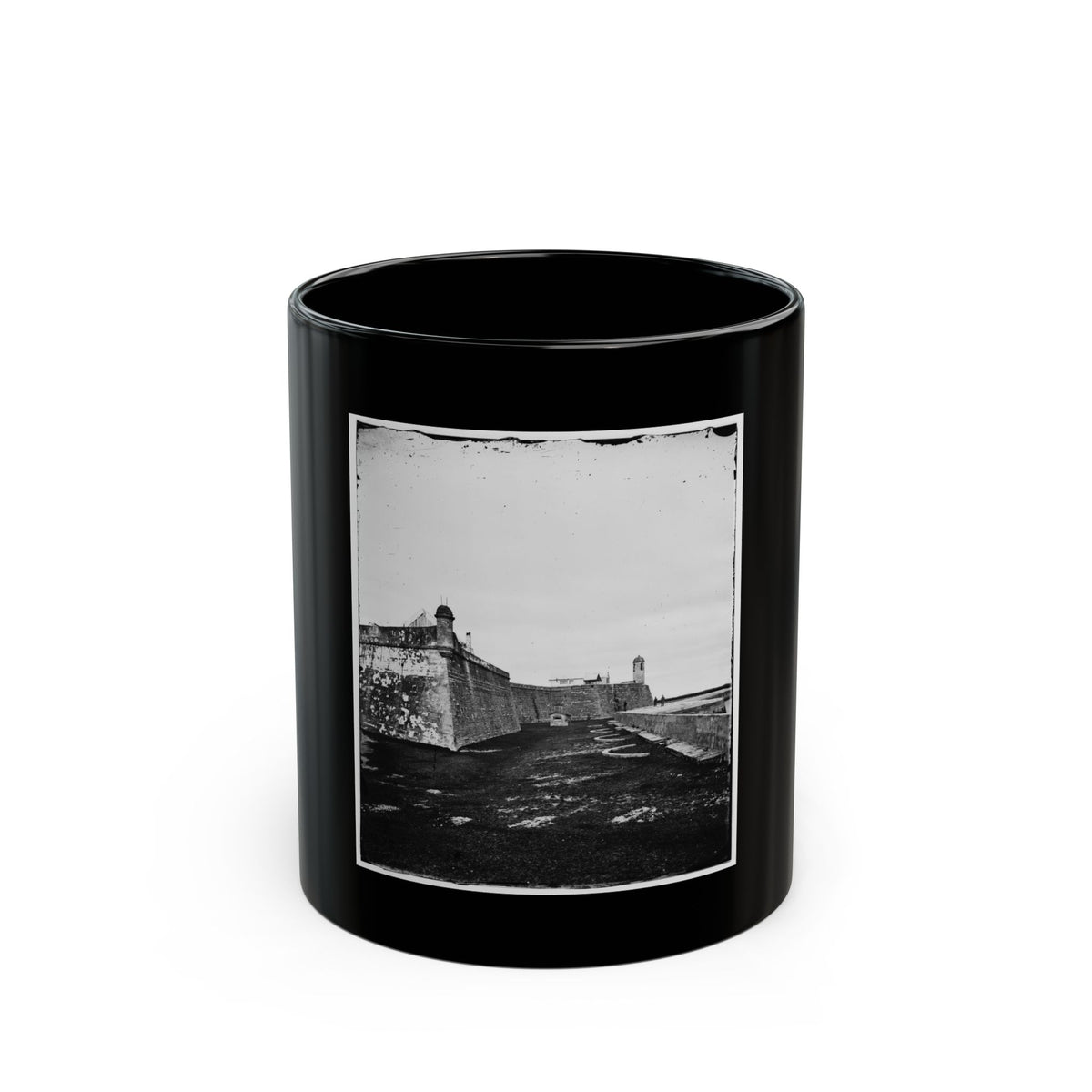 Black and white view of a stone fort with an angled corner bastion, a domed sentry tower and circular gun rings.