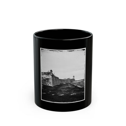 Black and white view of a stone fort with an angled corner bastion, a domed sentry tower and circular gun rings.