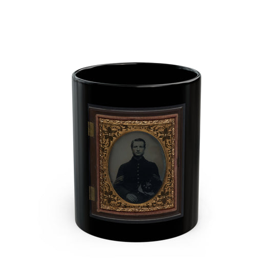 Antique tintype of a young man in a dark buttoned coat holding a kepi on his lap, set in an oval gilt case.