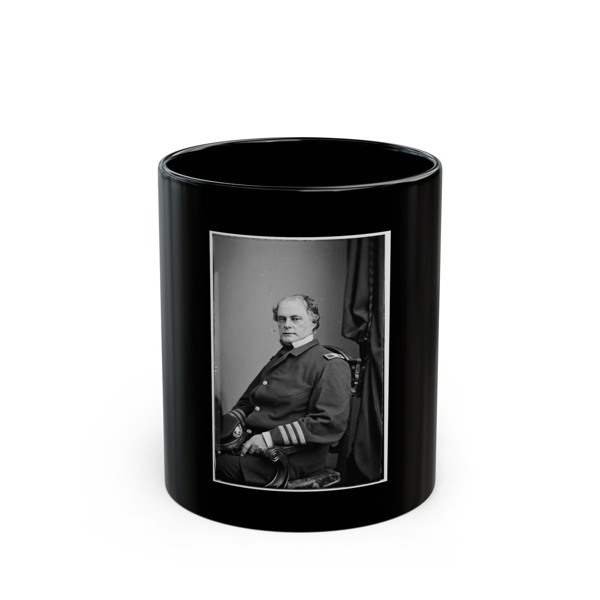 Black and white portrait of a seated man in a dark military coat with striped sleeve cuffs beside a carved chair.