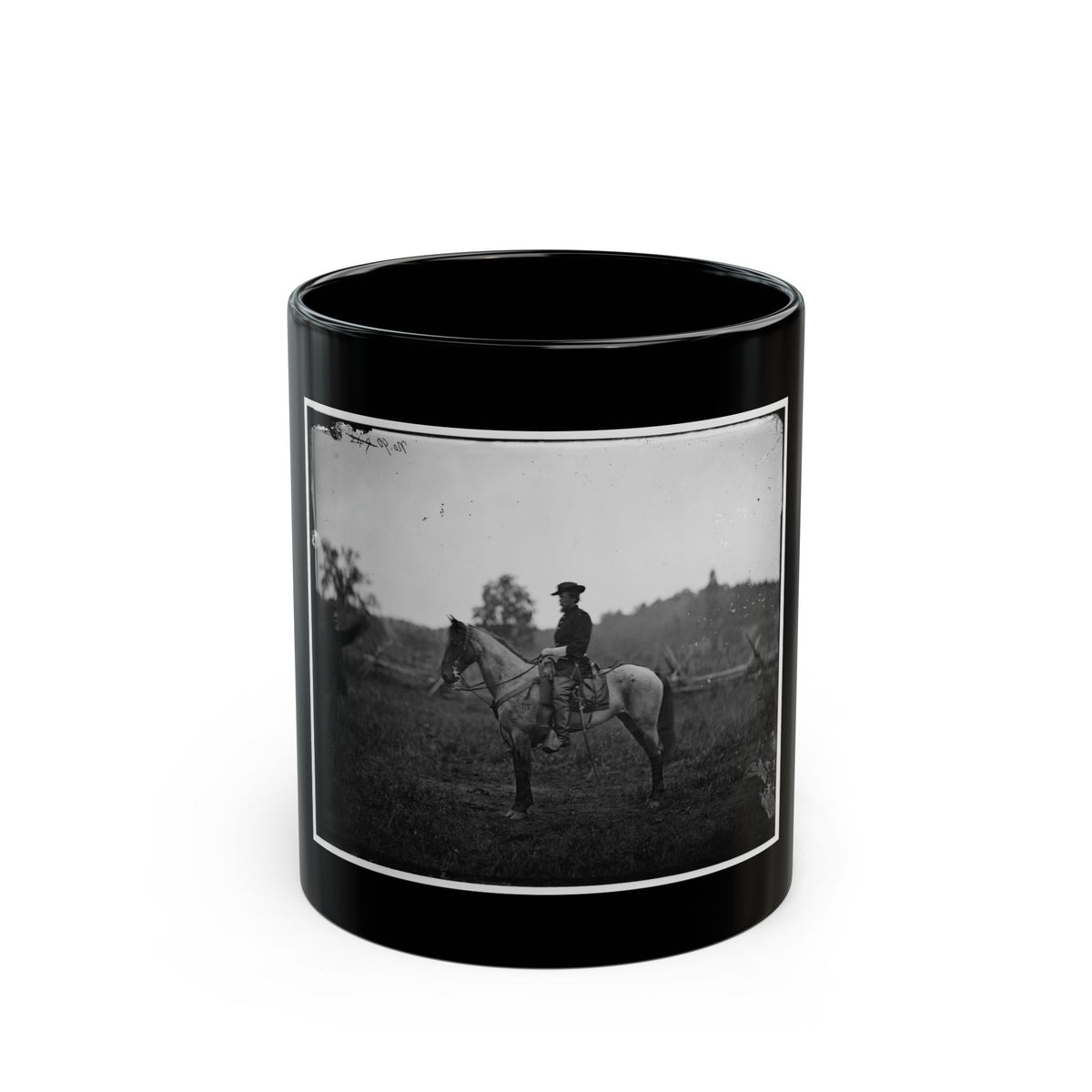 Black-and-white 1860s view of a mounted officer on a grey horse in an open field, a man standing at left.