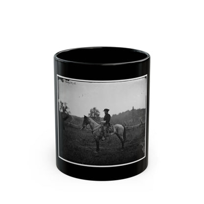 Black-and-white 1860s view of a mounted officer on a grey horse in an open field, a man standing at left.