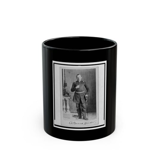 Black and white studio portrait of a standing man in a dark military uniform holding a sabre beside a pedestal.