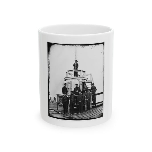 Black and white 1860s view of uniformed men posed around a small wooden lookout tower, with one man on top.