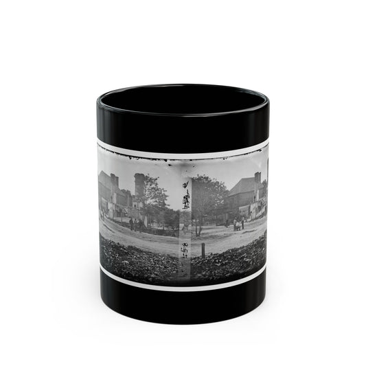 Black-and-white stereo view of a damaged brick building with broken chimneys and small figures on a dirt road.
