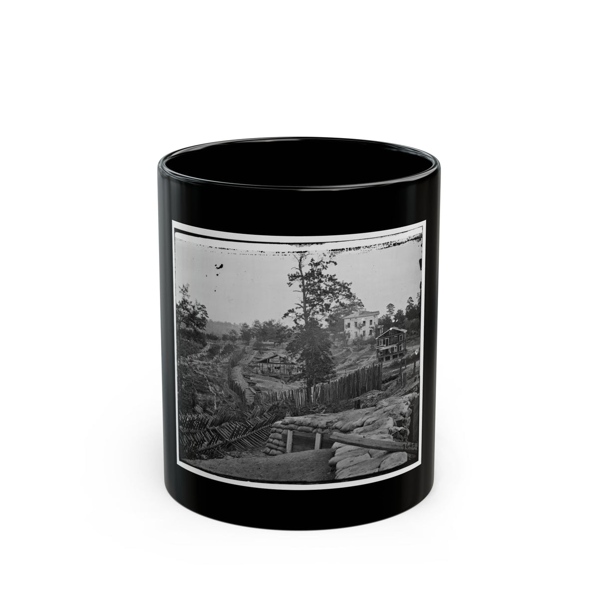 Black and white 1860s view of a sandbag parapet and sharpened timber barricades on a wooded hillside.
