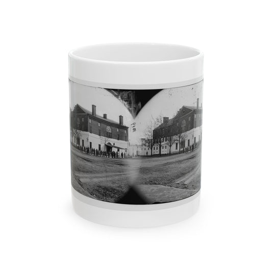 Black and white stereograph of a large brick building with a white base, and men standing on the lawn in front.