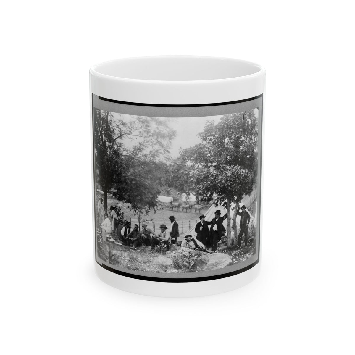 Black and white 19th-century scene of men resting and cooking beside a white canvas tent under shade trees.