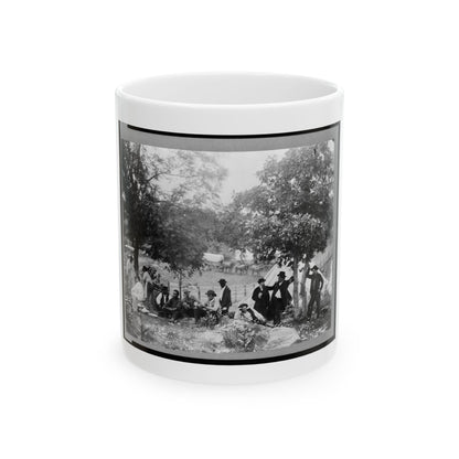 Black and white 19th-century scene of men resting and cooking beside a white canvas tent under shade trees.