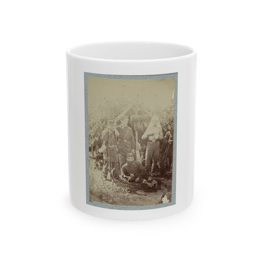 Sepia print showing soldiers in kepi caps beside a rough lean-to shelter, one seated and one holding a rifle.