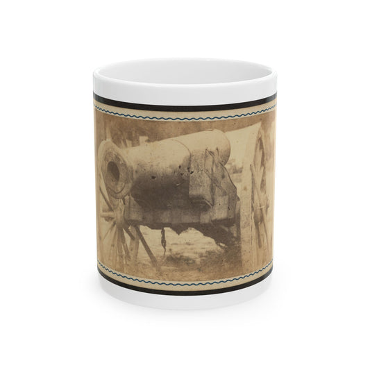Sepia scene of a muzzle-loading cannon on a spoked wooden carriage, framed by a card with a wavy blue border.