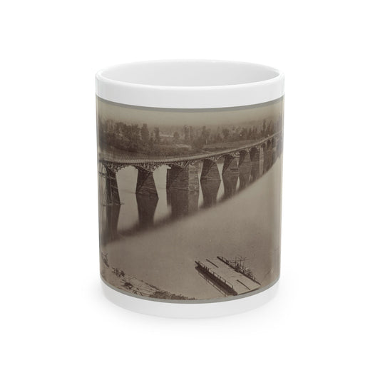 Sepia albumen print of a long timber trestle railway bridge with repeated piers crossing a wide river.