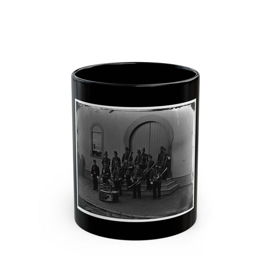 Black and white mid-19th-century view of a military band in dark uniforms with brass horns and bass drums.