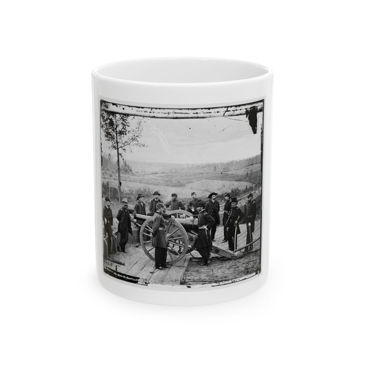 Black and white 1860s view of nine uniformed officers gathered around a spoked cannon on a wooden platform.