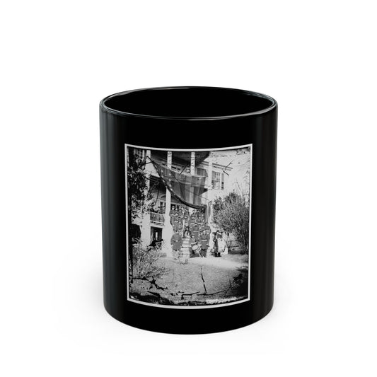 Black-and-white glass-plate print of a uniformed military band with drums on the steps of a columned house.
