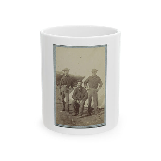 Sepia print showing three men in wide-brimmed hats posing before a white tent, one seated in the centre.