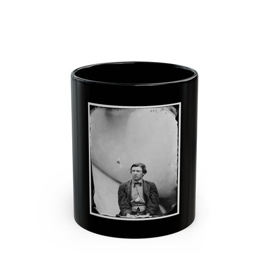 Black and white 1860s studio portrait of a seated man in a dark jacket, vest and bow tie against a pale backdrop.
