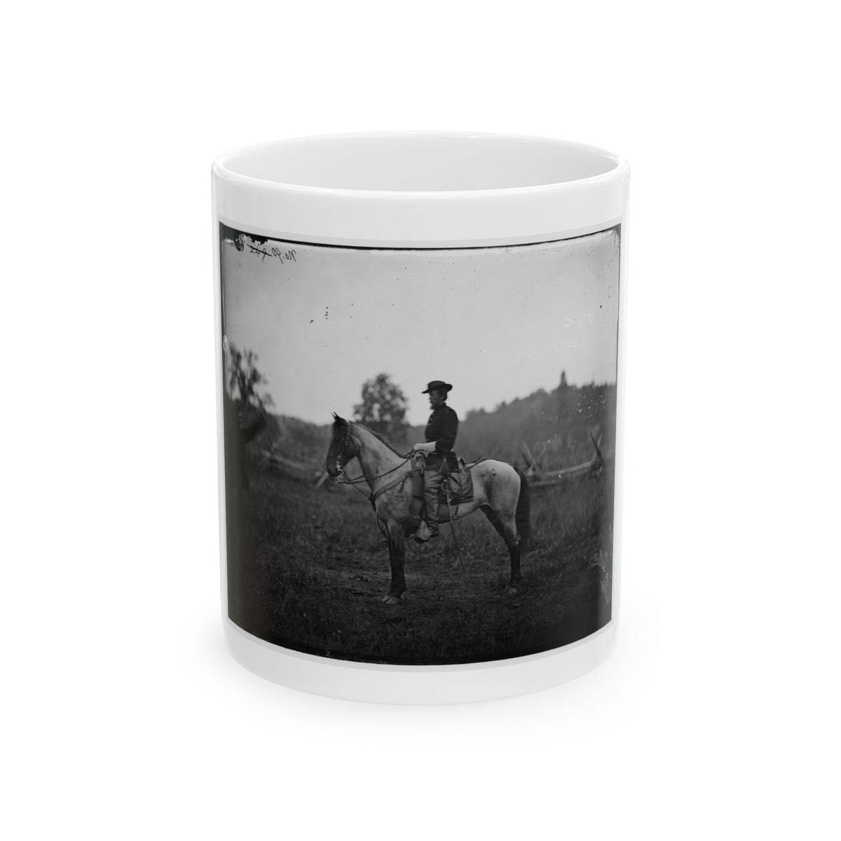 Black-and-white 1860s view of a mounted officer on a grey horse in an open field, a man standing at left.