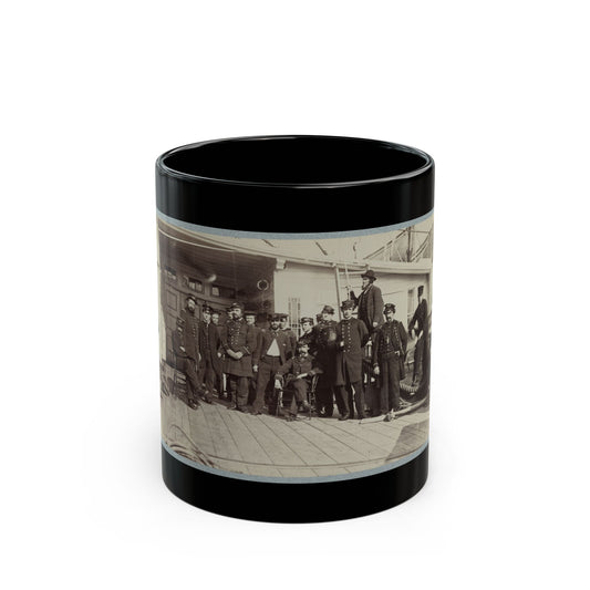 Sepia group scene of about fifteen uniformed naval officers posed on a wooden ship deck beside coiled ropes.