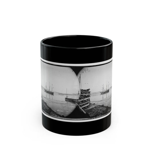 Black and white stereo view of ships at anchor in a calm harbour, a wharf stacked with cordwood in front.
