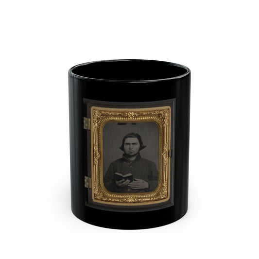 Antique tintype of a man holding a small open book, in an ornate gilt case with a velvet mat.