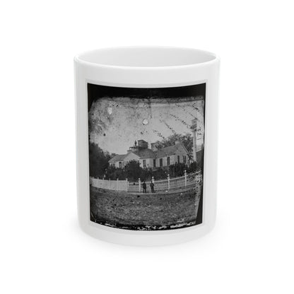 Black and white print of a two-storey wooden house with a rooftop lookout behind a white picket fence.