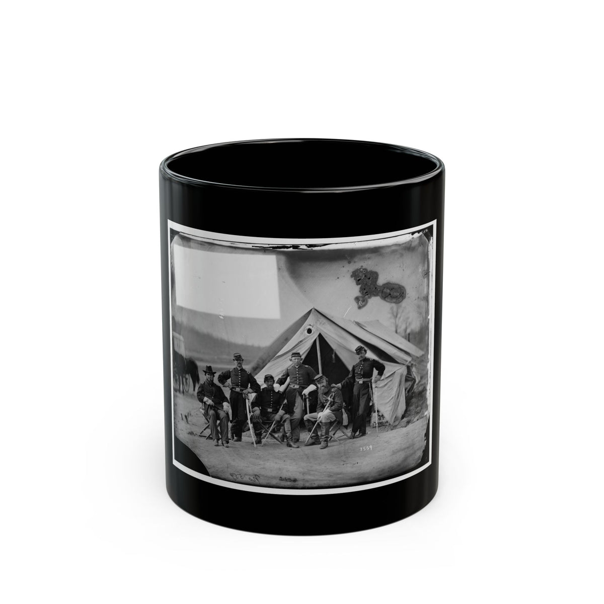Black and white view of six 1860s officers posed before a canvas tent, some seated on folding chairs.