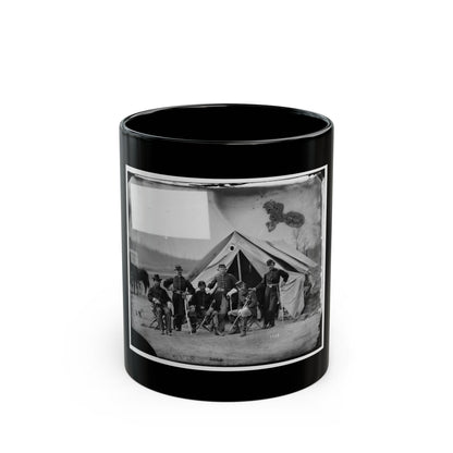 Black and white view of six 1860s officers posed before a canvas tent, some seated on folding chairs.
