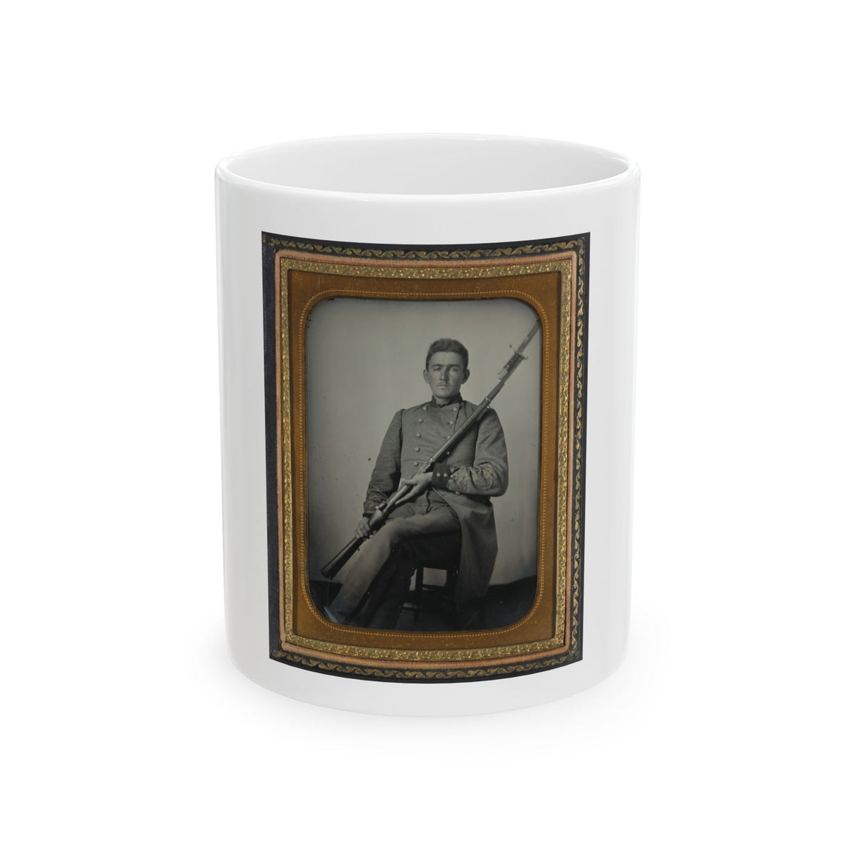 Antique tintype of a seated young man in a grey military coat holding a bayoneted rifle, in a gilt case.