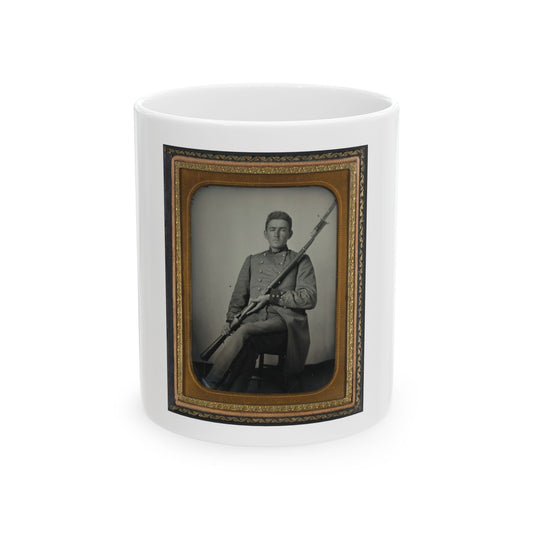 Antique tintype of a seated young man in a grey military coat holding a bayoneted rifle, in a gilt case.
