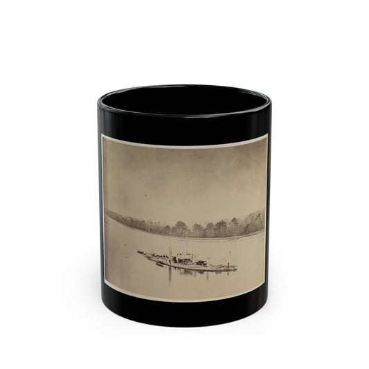 Sepia albumen print of a small military steamship with a smokestack on a wide river, with bare trees along the bank.