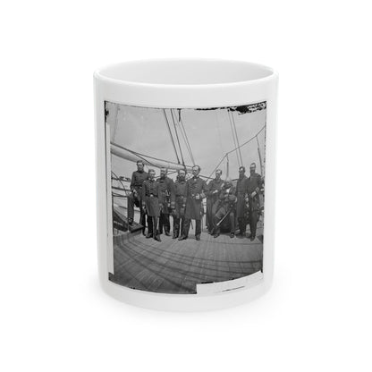 Black and white group portrait of nine uniformed officers, some with swords, on a wooden warship deck.