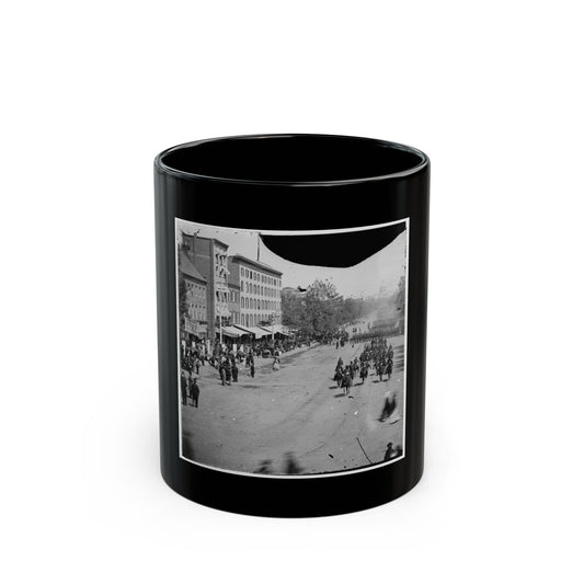 Black and white 1860s view of mounted riders and marching troops on a city avenue lined with spectators.