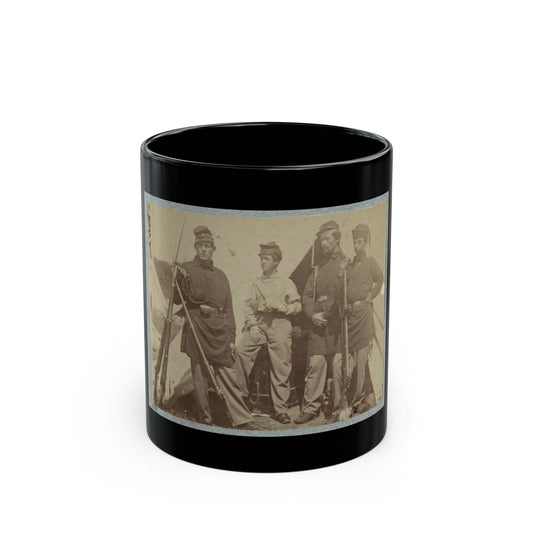 Sepia print showing four young soldiers in kepis standing with rifles in front of a canvas tent.