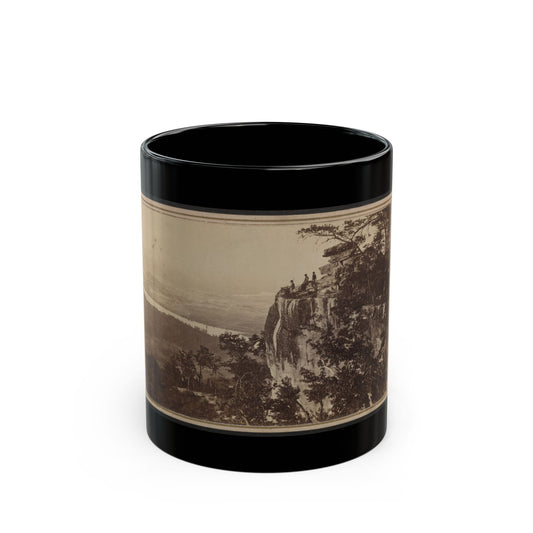 Sepia landscape scene of three figures on a rocky cliff edge above a wide valley and winding river.
