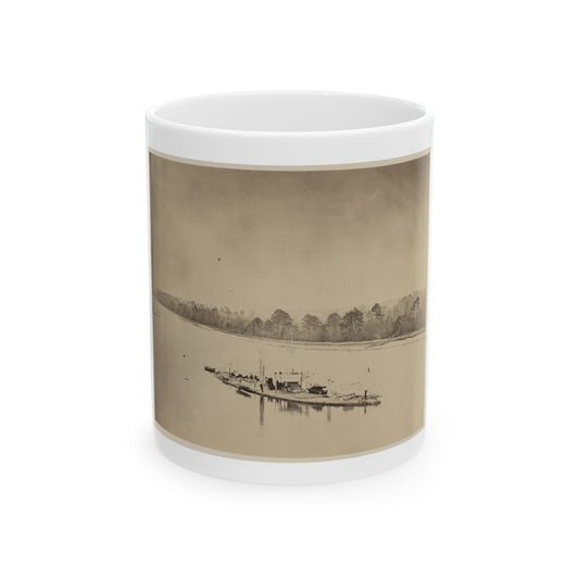 Sepia albumen print of a small military steamship with a smokestack on a wide river, with bare trees along the bank.
