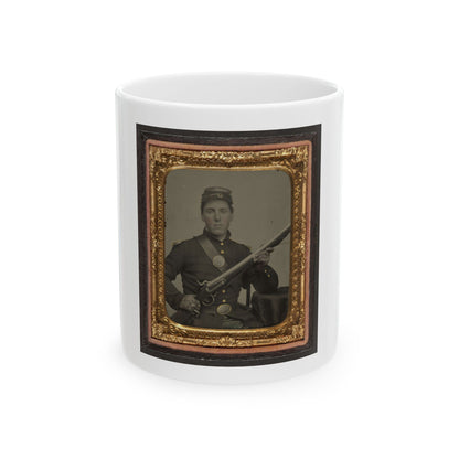 Hand-tinted tintype of a seated young soldier in dark uniform holding a rifle across his lap, in an ornate gold frame.